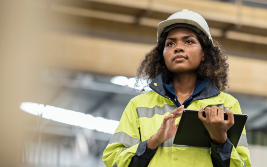 Woman wearing protective workwear using a tablet. 