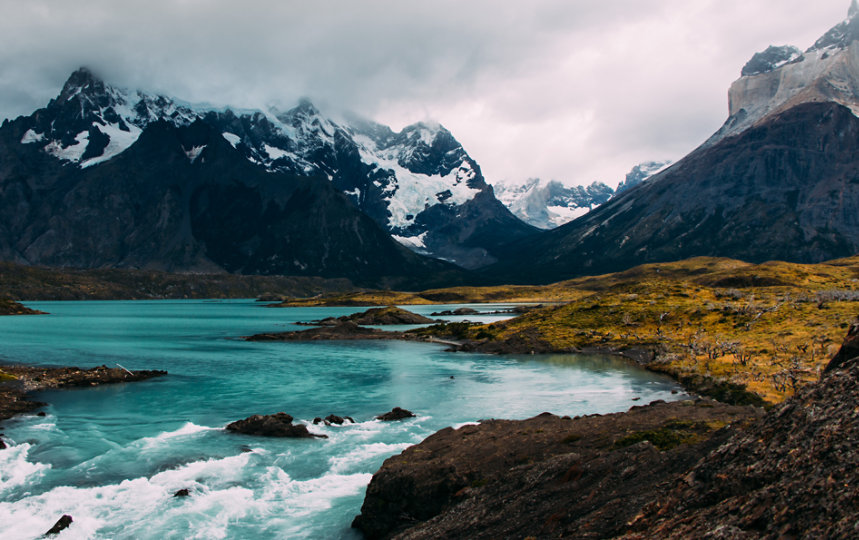 Proglacial river running through snowy mountains. 