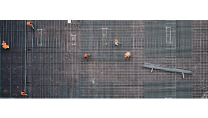 Aerial view of construction workers working on a steel grid foundation.