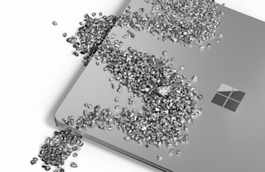 Small fragments of metal scattered over the top of a closed Surface laptop