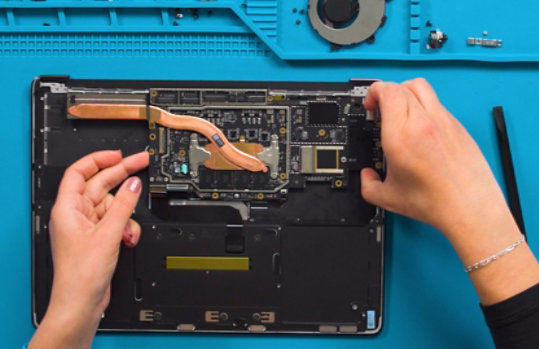 Person removes parts from a circuit board.
