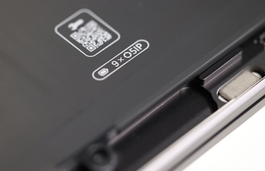 A QR code and wayfinding label on a Surface device which aid in repairing components.