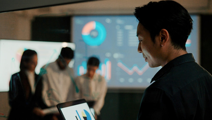 A businessman works on a laptop preparing a project proposal.