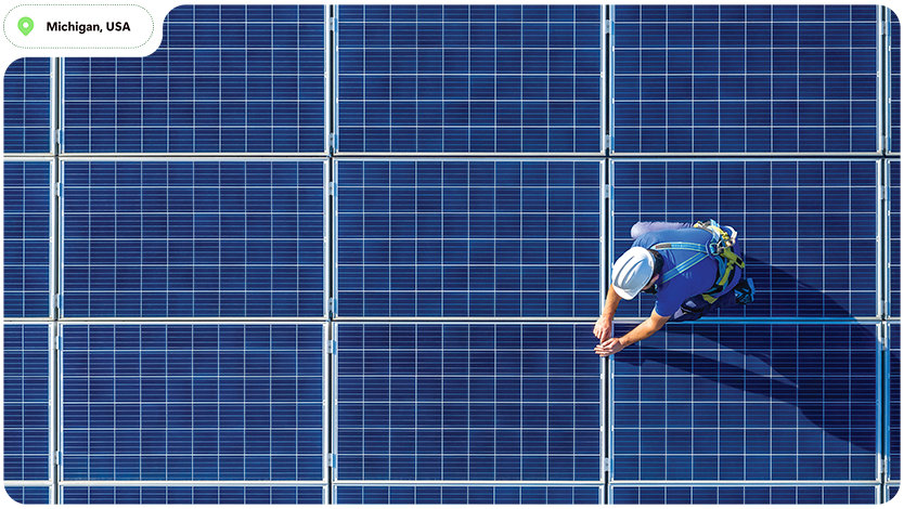 Worker inspecting solar panels in Michigan, USA.