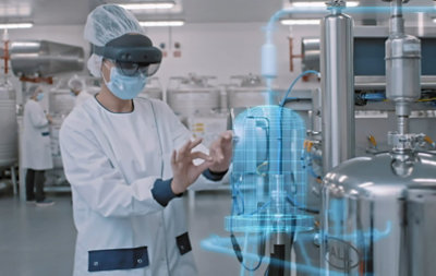A worker wearing mask and hair net using HoloLens 2 to view a 3D diagram in mixed reality