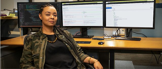 A woman sitting in front of two monitors