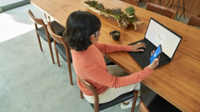 A hand holding a mobile phone displaying a request to approve sign-in in Microsoft Authenticator.