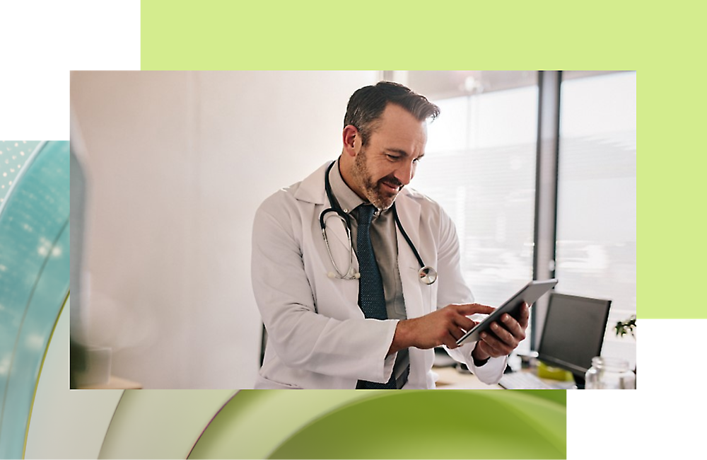 Um médico de jaleco branco e gravata olhando para um tablet