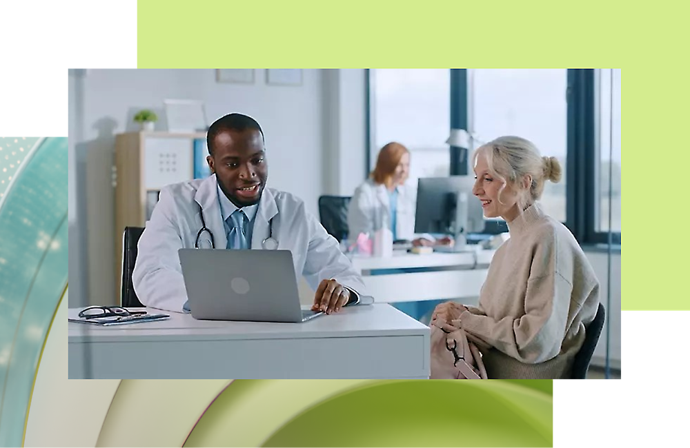 Лікар і пацієнт дивляться на екран комп’ютера