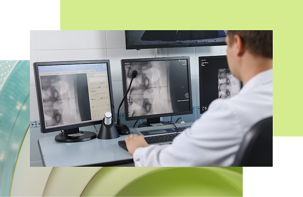 Un médico mira una radiografía en varios monitores