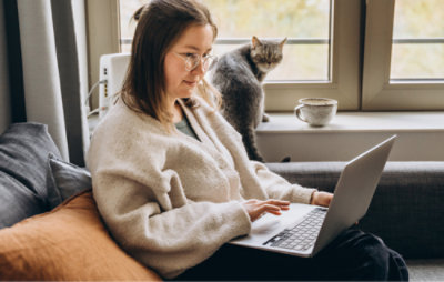 ソファに座る人。背景には猫がいます