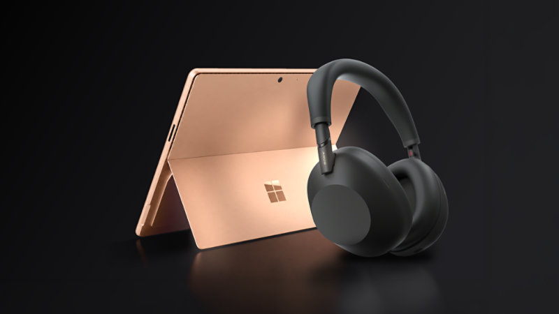 A 13-inch, Dune Surface Pro with a pair of black Sony wireless headphones.