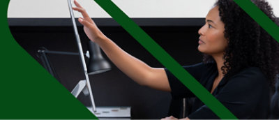 一名捲髮女士與電腦螢幕互動，朝螢幕伸手