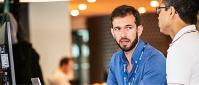 Twee mannen in een vergaderruimte die met elkaar praten.