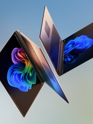 Laptops tumbling through the air, displaying Windows 11 screens. 