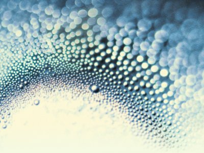 Water droplets and circles on a white and dark blue gradient background.