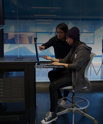 A woman pointing at a laptop.