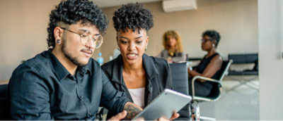 Kaksi henkilöä katsovat tablettia