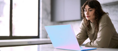 A person sitting at a table using a laptop.