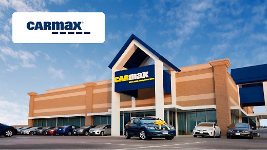 A CarMax storefront with cars parked in front