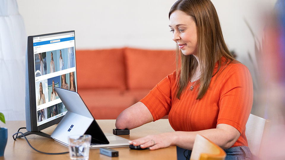 A person with a physical disability uses Microsoft adaptive accessories with her Surface device.