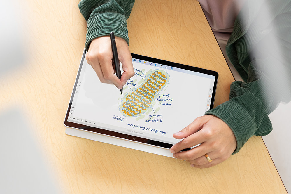 A person uses a Slim Pen 2 on the touchscreen of a Surface Pro 9.