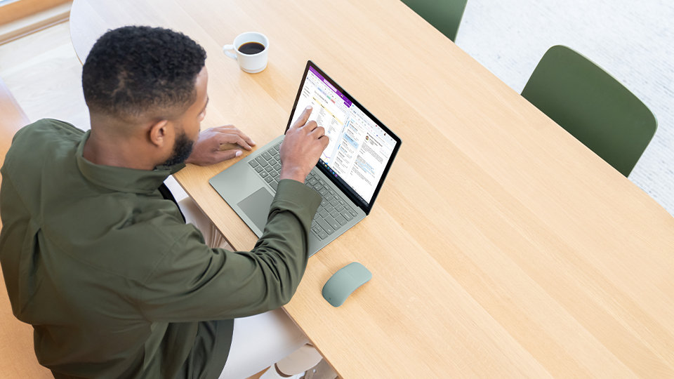 En person använder Microsoft 365-appar på Surface Laptop 5 för företag. 