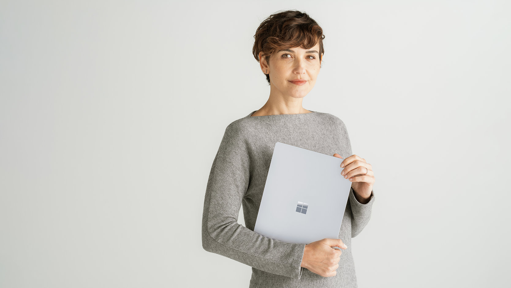 法人向け Surface Laptop 6 を持ち運んで、ハードウェアとソフトウェアの保護の信頼性をアピールする人物。