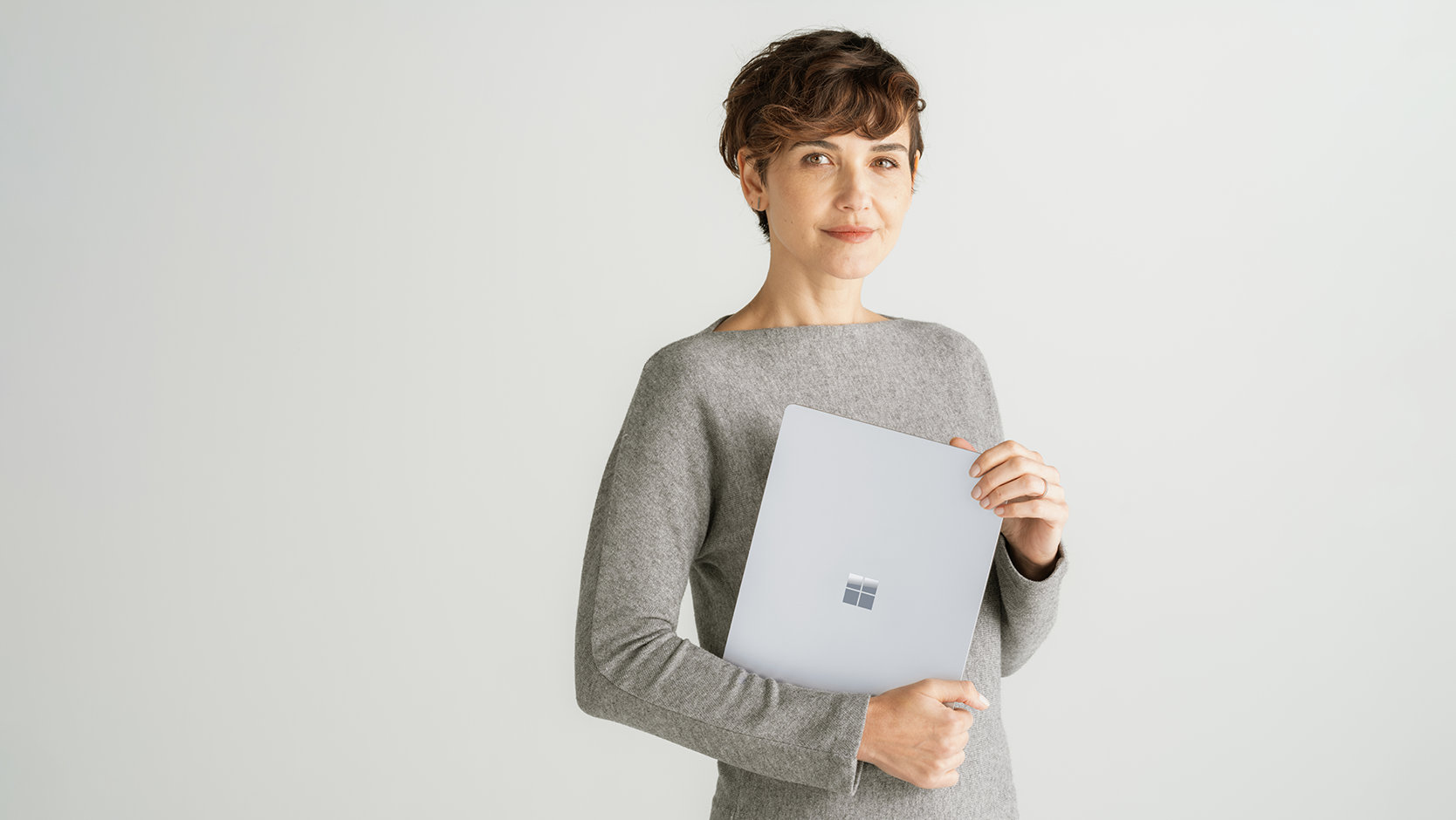 En person bär på en Surface Laptop 6 för företag för att visa tillförlitligheten hos hårdvaru- och programvaruskyddet.