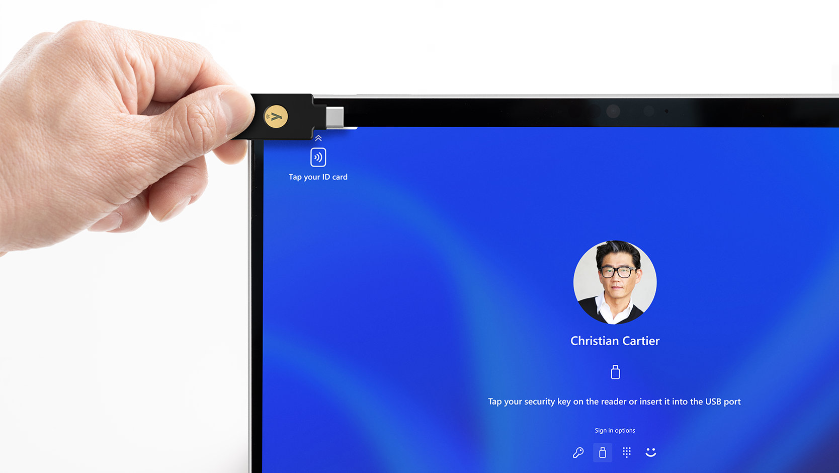 法人向け Surface Pro 10 で NFC リーダーを使用し、デバイスのさまざまな組み込みのセキュリティ対策機能を示す人物。