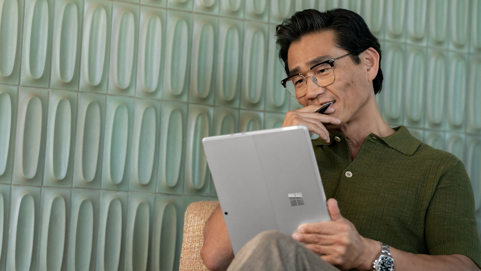 A person uses a Surface Pro 10 for Business as a tablet. 