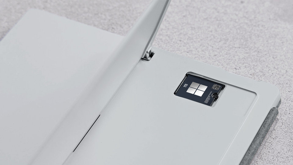 A closeup view of Surface Pro 9 for Business open to show the removable hard drive.