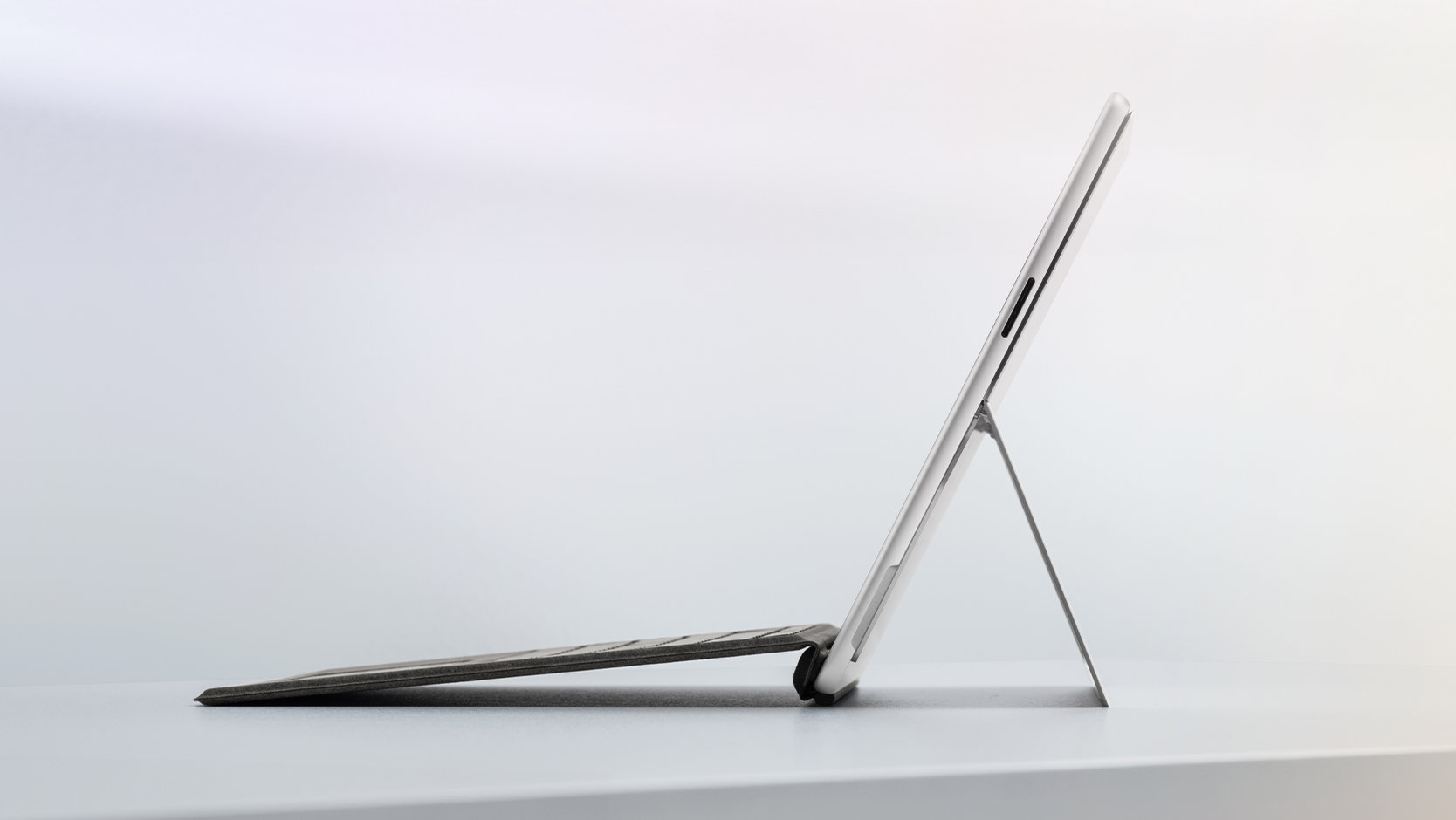 En Surface Pro til erhverv set fra siden fastgjort til et Surface Pro Flex Keyboard til erhverv.