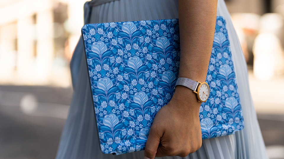 Une personne transporte un clavier Surface Pro Liberty en marchant sur la rue.