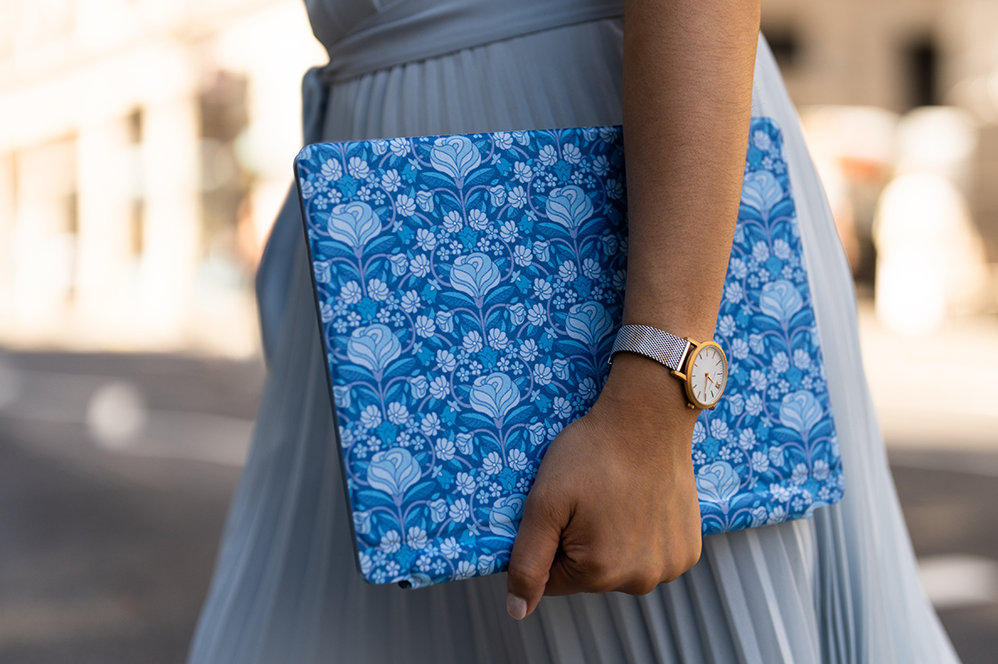 A person carries a Surface Pro Liberty Keyboard while walking down the street.