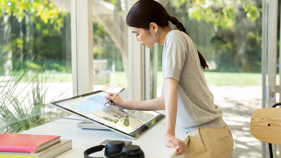 Une personne utilise un stylet Surface pour travailler sur l’écran de Surface Studio 2+ pour les entreprises.