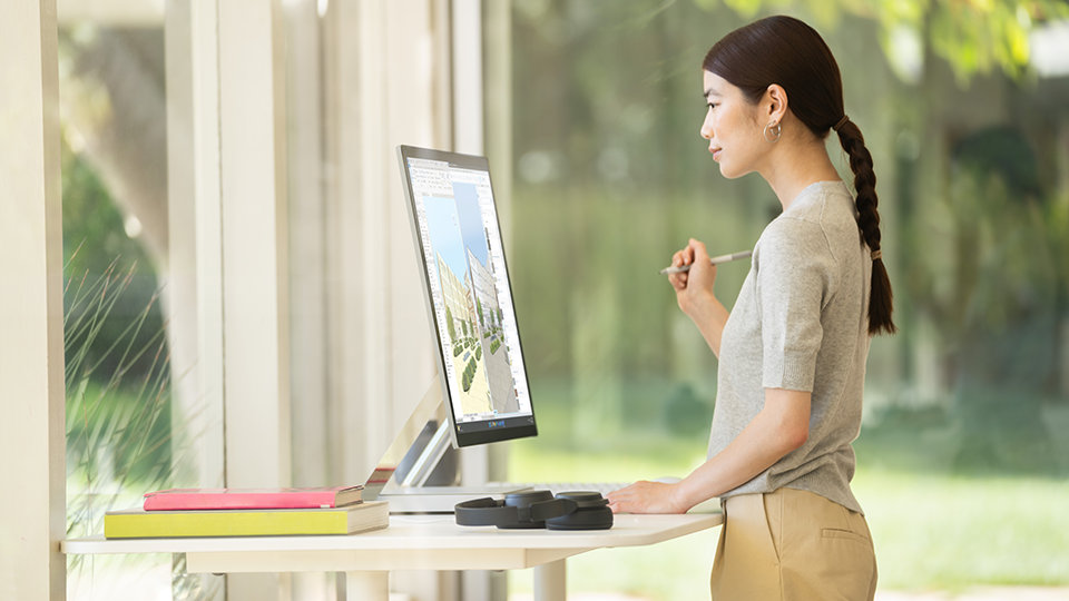 Une personne assise à un bureau utilise son clavier pour travailler sur Surface Studio 2+ pour les entreprises.