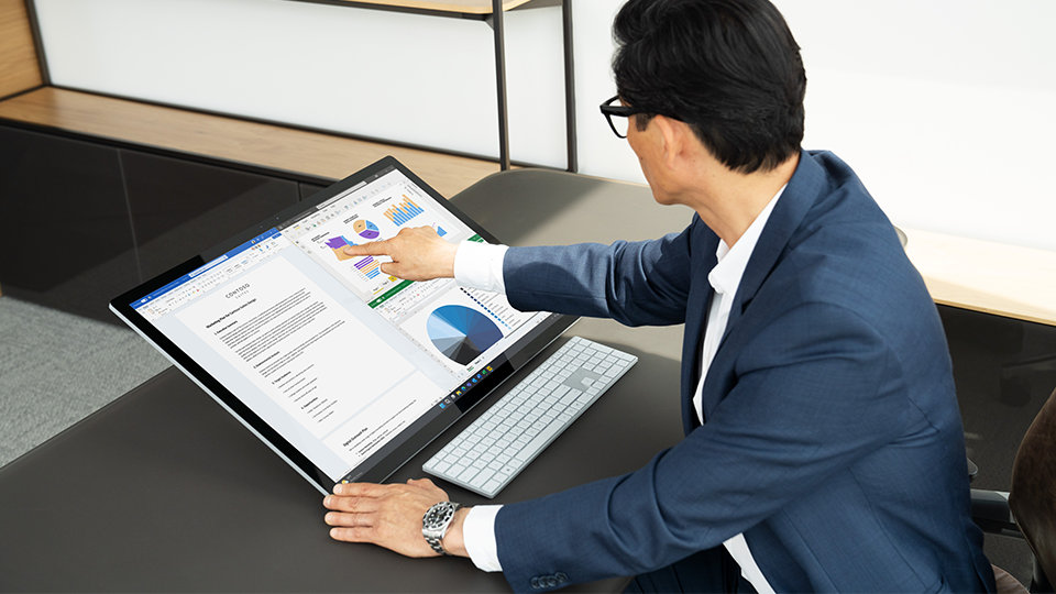 A person uses Microsoft 365 apps on Surface Studio 2+ for Business.