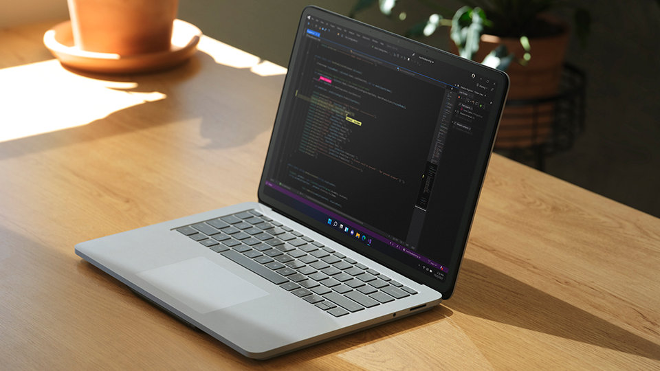 Un ordinateur portable sur un bureau avec Visual Studio à l’écran.