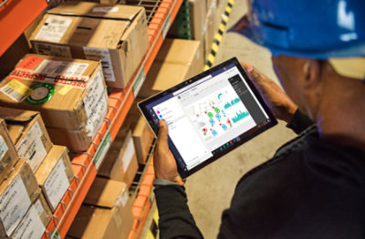 A person wearing a hard hat using a tablet device to view a chart.