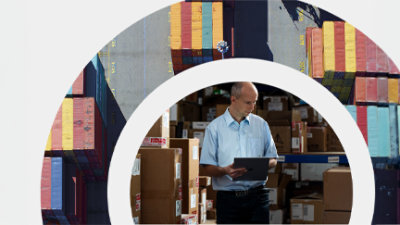 Eine Person, die einen Computer in einem Lager hält