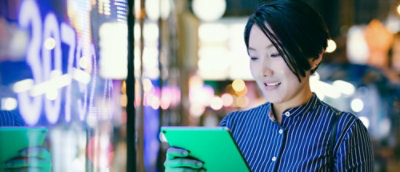 Osoba v modré košili, která se dívá na tablet