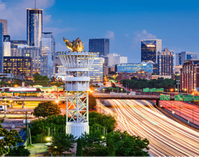 前景にあるたいまつのような構造物とライトアップされた建物のある都市景観の夜景 