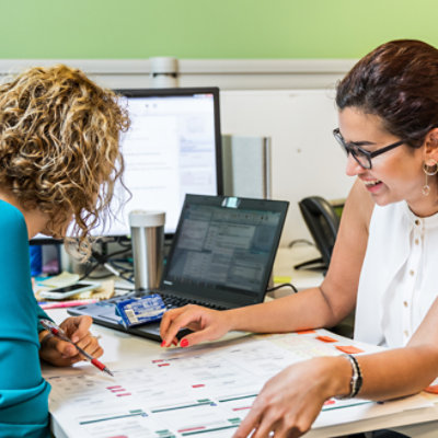 Two people looking at paperwork on a desk
