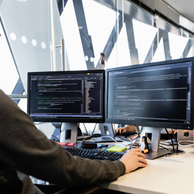 Two desktop monitors displaying code