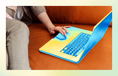 A hand resting on a laptop keyboard.