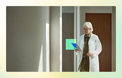 A person in a white coat holding a clipboard.