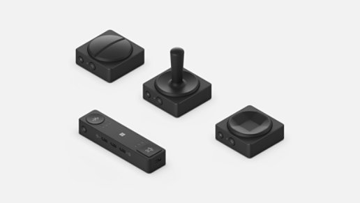 Microsoft Adaptive Hub рядом с тремя кнопками адаптивных аксессуаров Microsoft.