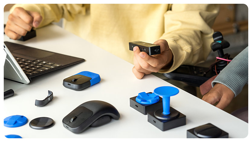 Une variété d’accessoires en mode tactile adaptatif conçus pour les personnes à mobilité réduite reposent sur une table. 
