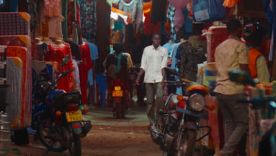 Man walking through a busy walkway in a refugee camp in Kakuma,  Kenya.